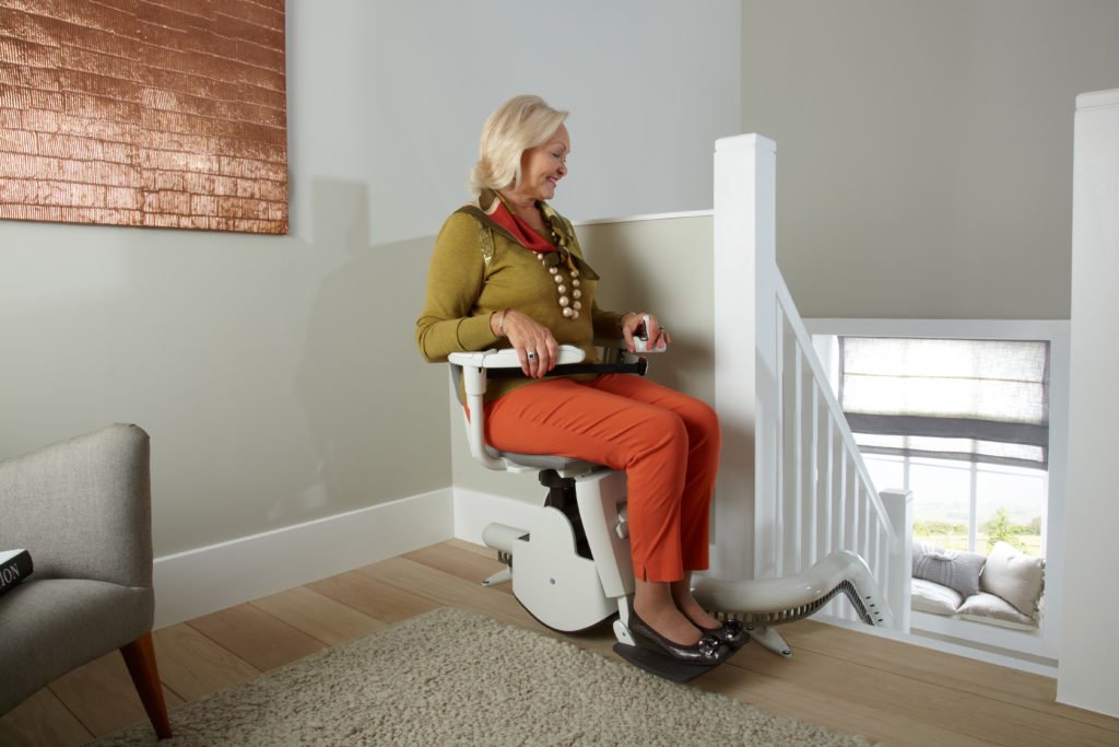 Woman on Stairlift- Stairlifts, Stairlift repairs, stairlift rentals in Cirencester, Newbury, Malmesbury,