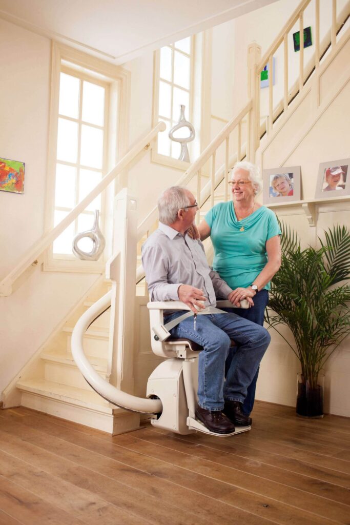 Elderly Man and Woman using a Stairlift - Stairlifts, Stairlift repairs, stairlift rentals in Cirencester, Newbury, Malmesbury,